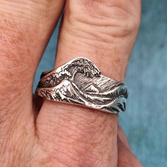 a photo of silver ring in the shape of the great wave off kanagawa.