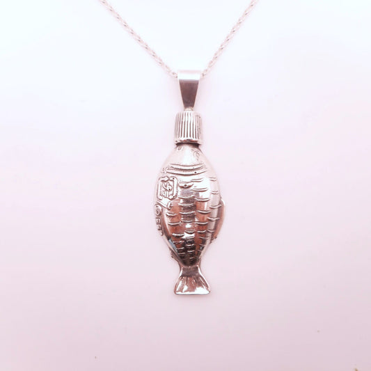 A photo of a soy sauce fish bottle made of silver, attached to a chain, on a white background.